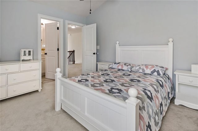 bedroom featuring vaulted ceiling and light carpet