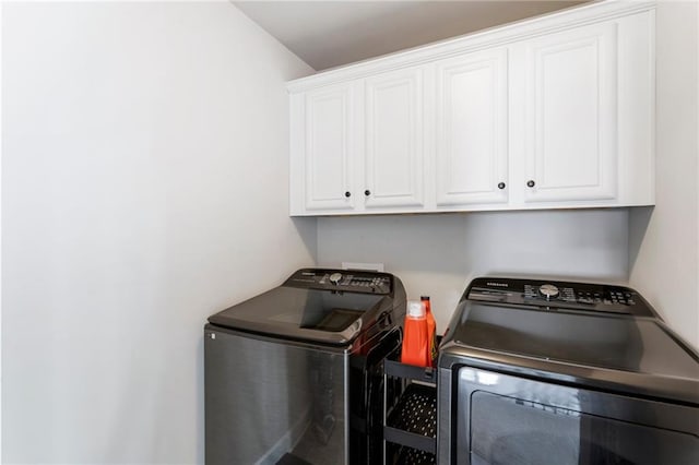 laundry room featuring cabinets and washer and clothes dryer