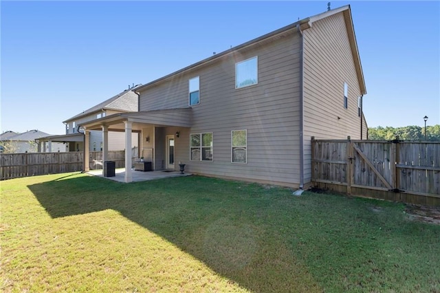 rear view of property featuring a lawn and a patio