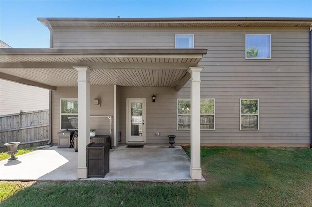 back of house featuring a patio and a lawn