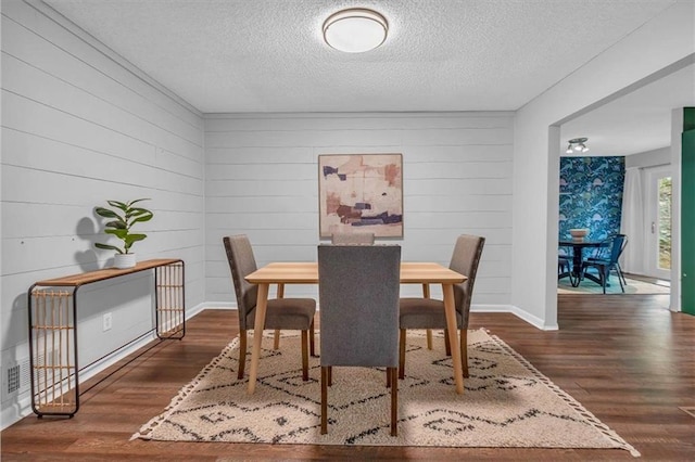 dining room with a textured ceiling and wood finished floors