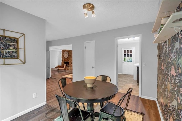 dining area with baseboards and wood finished floors