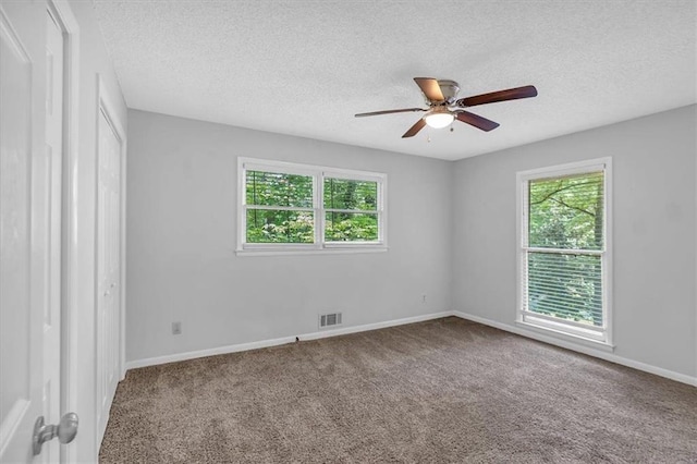 unfurnished room with visible vents, a ceiling fan, a textured ceiling, and carpet flooring