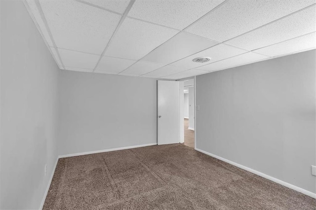 carpeted empty room with baseboards and a paneled ceiling