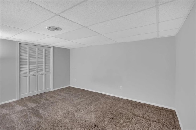 unfurnished bedroom featuring baseboards, carpet, and a drop ceiling