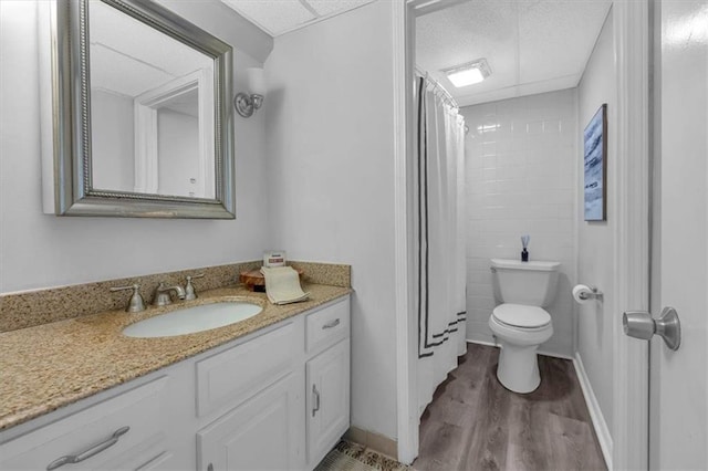 bathroom featuring vanity, wood finished floors, toilet, and curtained shower