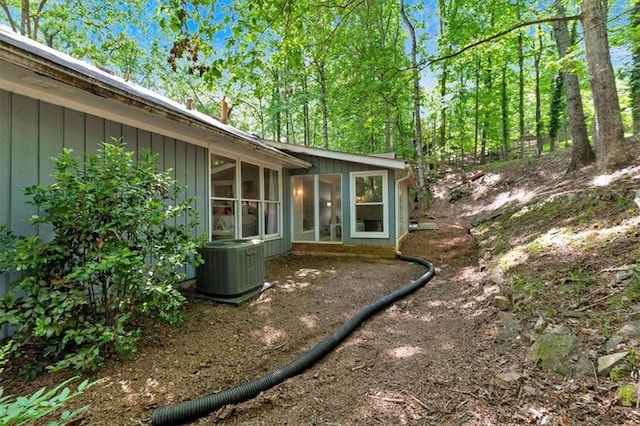view of side of home with a sunroom and cooling unit