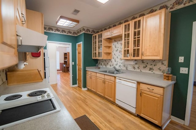 kitchen with sink, light hardwood / wood-style floors, white appliances, and light brown cabinets