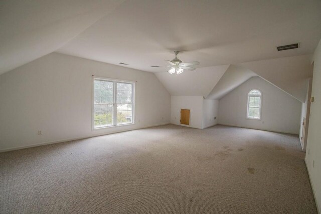 bonus room featuring a wealth of natural light, lofted ceiling, light colored carpet, and ceiling fan