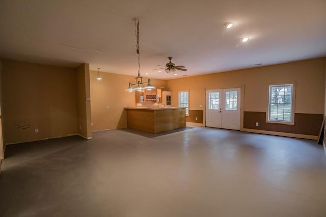 interior space featuring french doors, decorative light fixtures, concrete floors, and ceiling fan