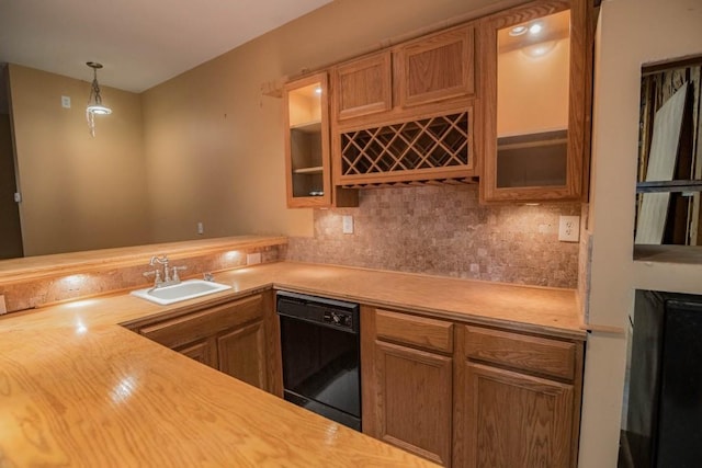 kitchen featuring sink, backsplash, dishwasher, and pendant lighting