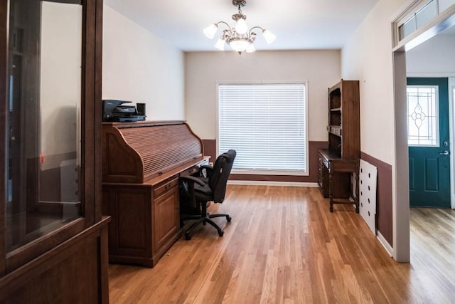 office featuring light hardwood / wood-style flooring and an inviting chandelier