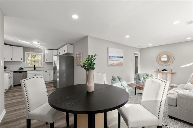 dining space with hardwood / wood-style flooring and sink