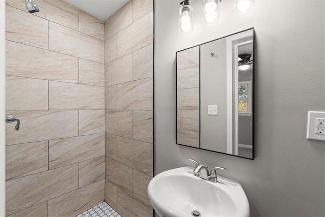 bathroom featuring a tile shower and sink