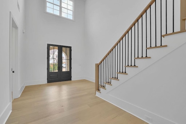 foyer featuring french doors, a high ceiling, and light hardwood / wood-style flooring