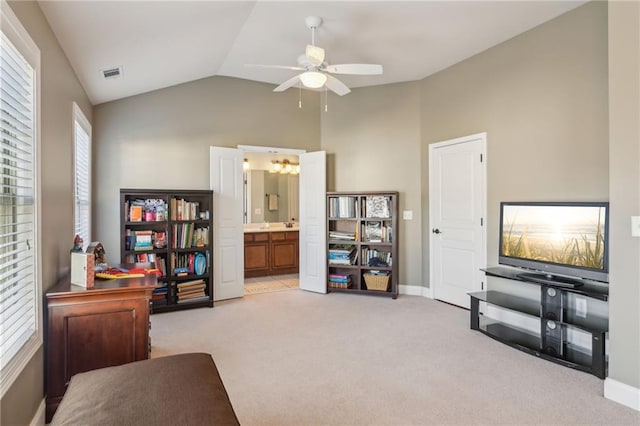 living area featuring vaulted ceiling, light colored carpet, and ceiling fan