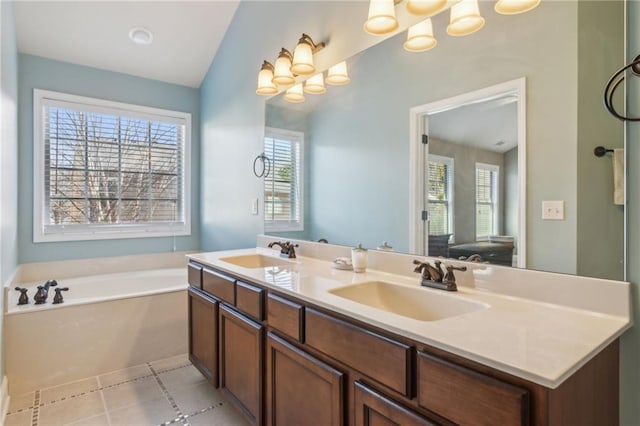 bathroom with vanity, a bath, tile patterned flooring, and a healthy amount of sunlight