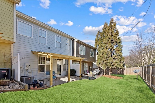 rear view of house with cooling unit, a patio area, and a lawn