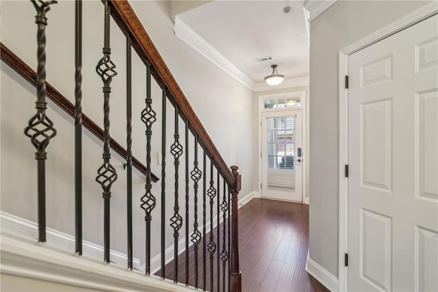 entryway with ornamental molding and dark hardwood / wood-style flooring