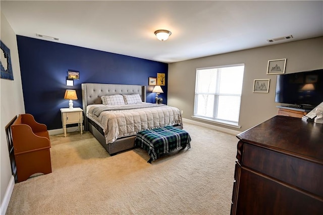 bedroom with light colored carpet, visible vents, and baseboards