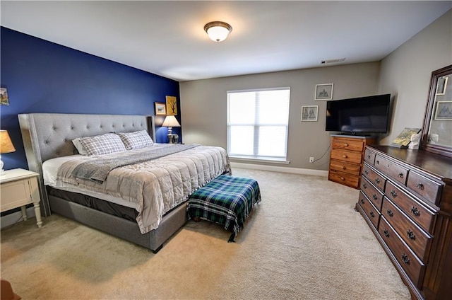 bedroom with light carpet and baseboards