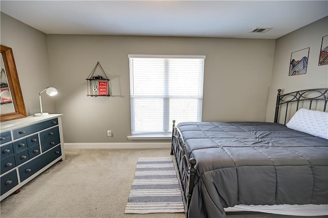 bedroom featuring visible vents, light carpet, and baseboards