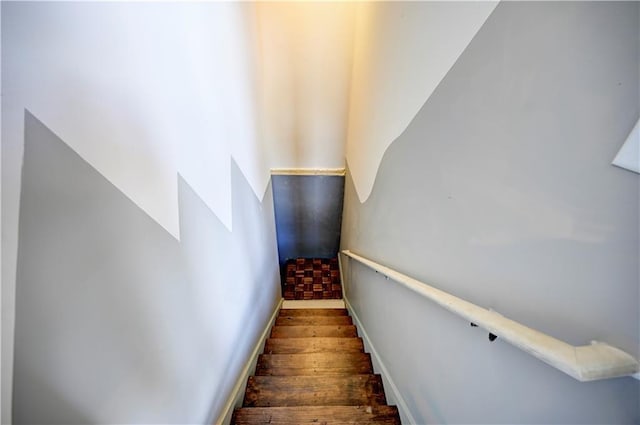 stairway featuring wood finished floors and baseboards