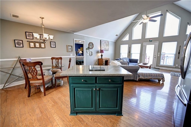 kitchen featuring a center island, freestanding refrigerator, light wood-type flooring, green cabinetry, and ceiling fan with notable chandelier