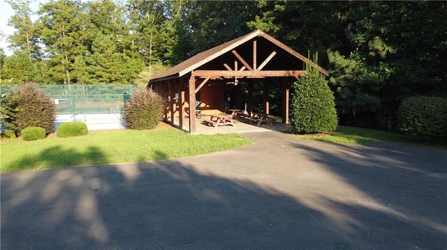 view of community with a lawn, fence, a patio, and a gazebo