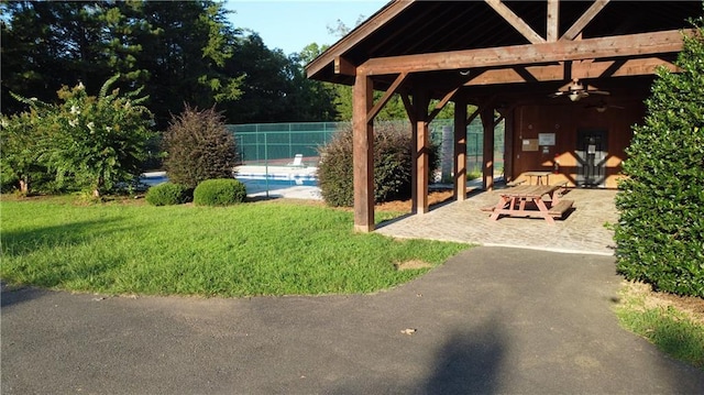 surrounding community with a pool, a patio area, and fence