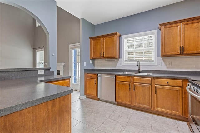 kitchen featuring stainless steel appliances, sink, decorative backsplash, and a wealth of natural light