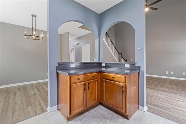 kitchen with an inviting chandelier, decorative light fixtures, and light wood-type flooring