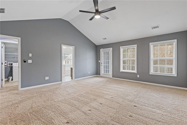 interior space featuring lofted ceiling, a healthy amount of sunlight, and light carpet