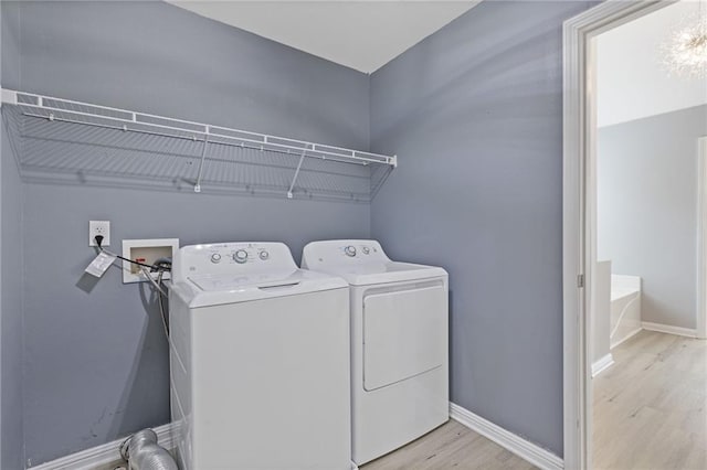 laundry area featuring washer and dryer and light hardwood / wood-style floors