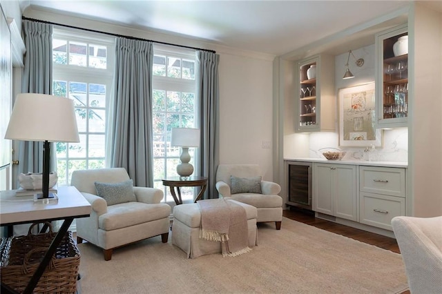 living area with hardwood / wood-style floors, beverage cooler, and bar area