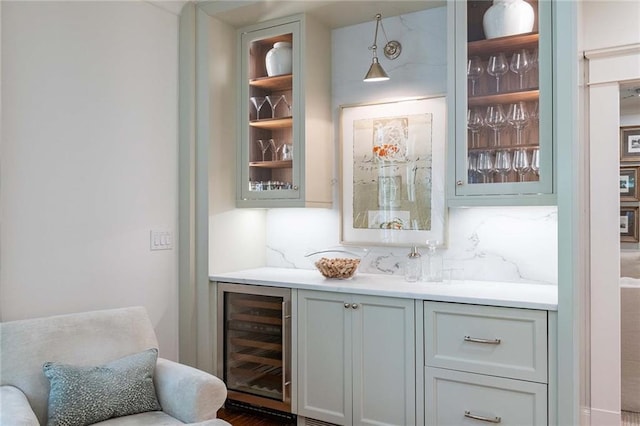 bar featuring decorative backsplash, beverage cooler, and decorative light fixtures