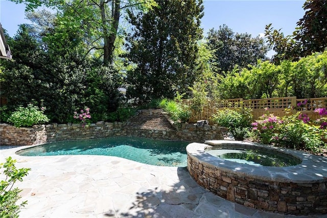 view of pool with a patio area and an in ground hot tub