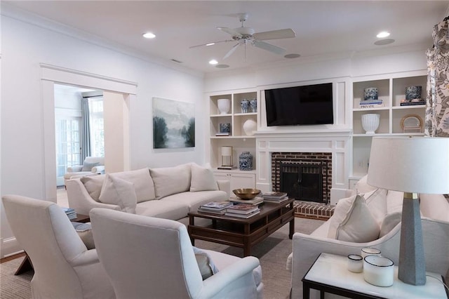 living room featuring a fireplace, ceiling fan, and ornamental molding