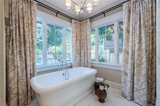 bathroom with a chandelier, plenty of natural light, and a bathtub