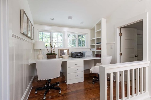 home office with lofted ceiling, dark hardwood / wood-style flooring, built in desk, and built in features