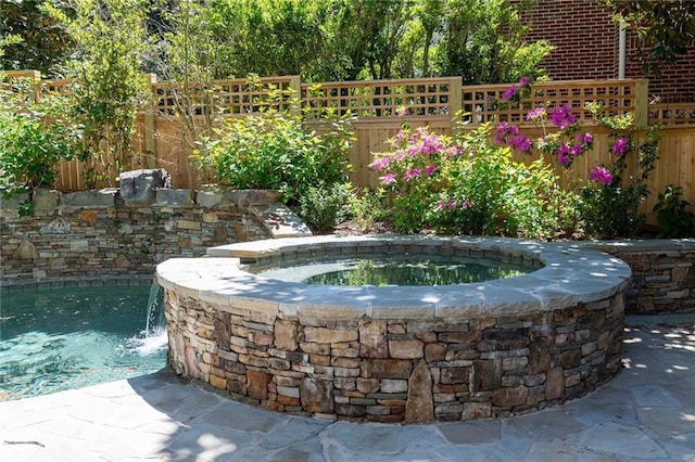 view of swimming pool with an in ground hot tub and pool water feature