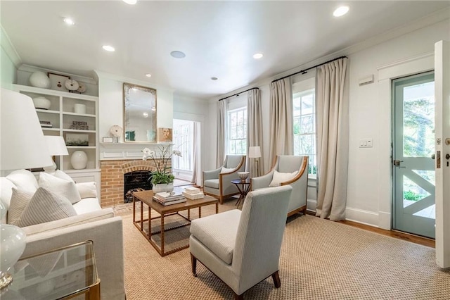 sitting room featuring light hardwood / wood-style floors, a brick fireplace, and crown molding