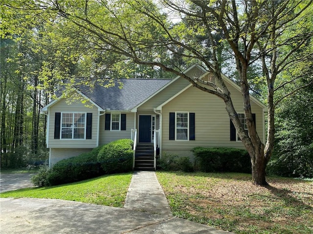 view of front of property with a shingled roof and a front yard