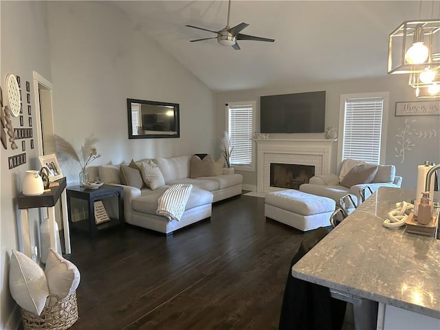 living area with dark wood-style floors, high vaulted ceiling, a fireplace, and a ceiling fan