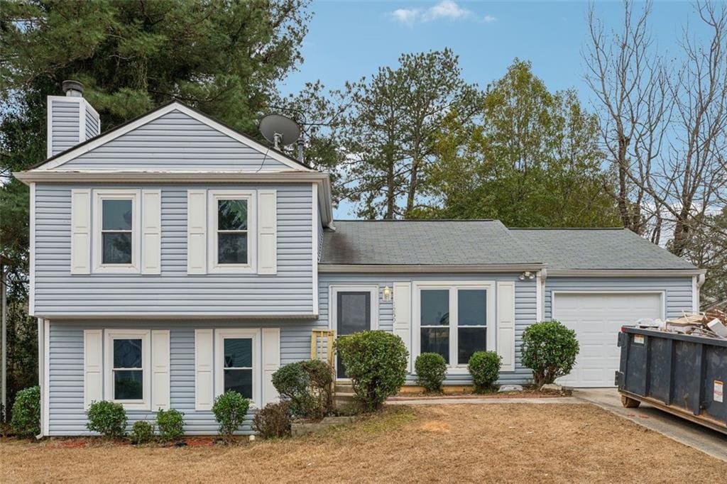 view of front of home with a garage and a front lawn