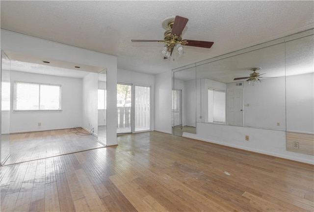 empty room featuring hardwood / wood-style flooring, plenty of natural light, ceiling fan, and a textured ceiling