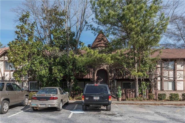 exterior space with uncovered parking and brick siding