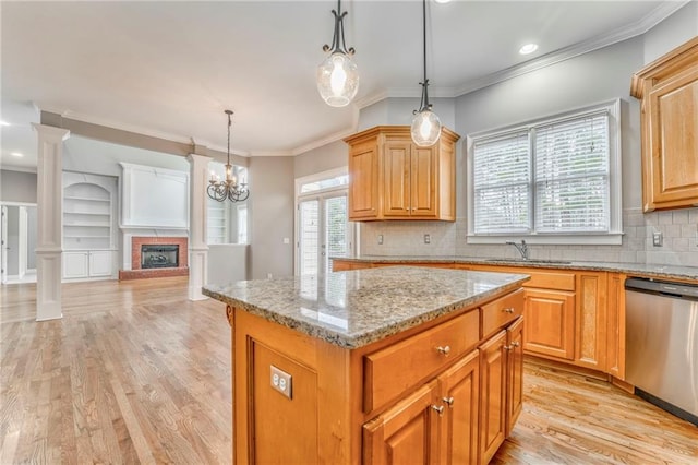 kitchen featuring sink, hanging light fixtures, ornamental molding, a kitchen island, and stainless steel dishwasher