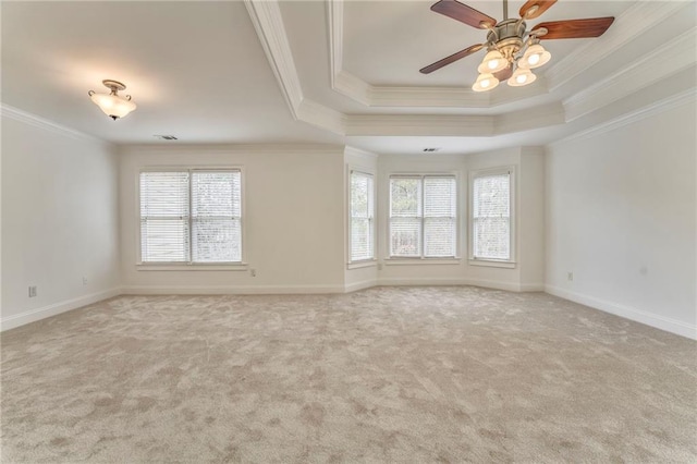 carpeted spare room with a raised ceiling, crown molding, and ceiling fan