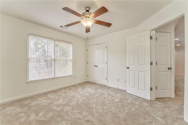 unfurnished bedroom with ceiling fan, light colored carpet, and a closet